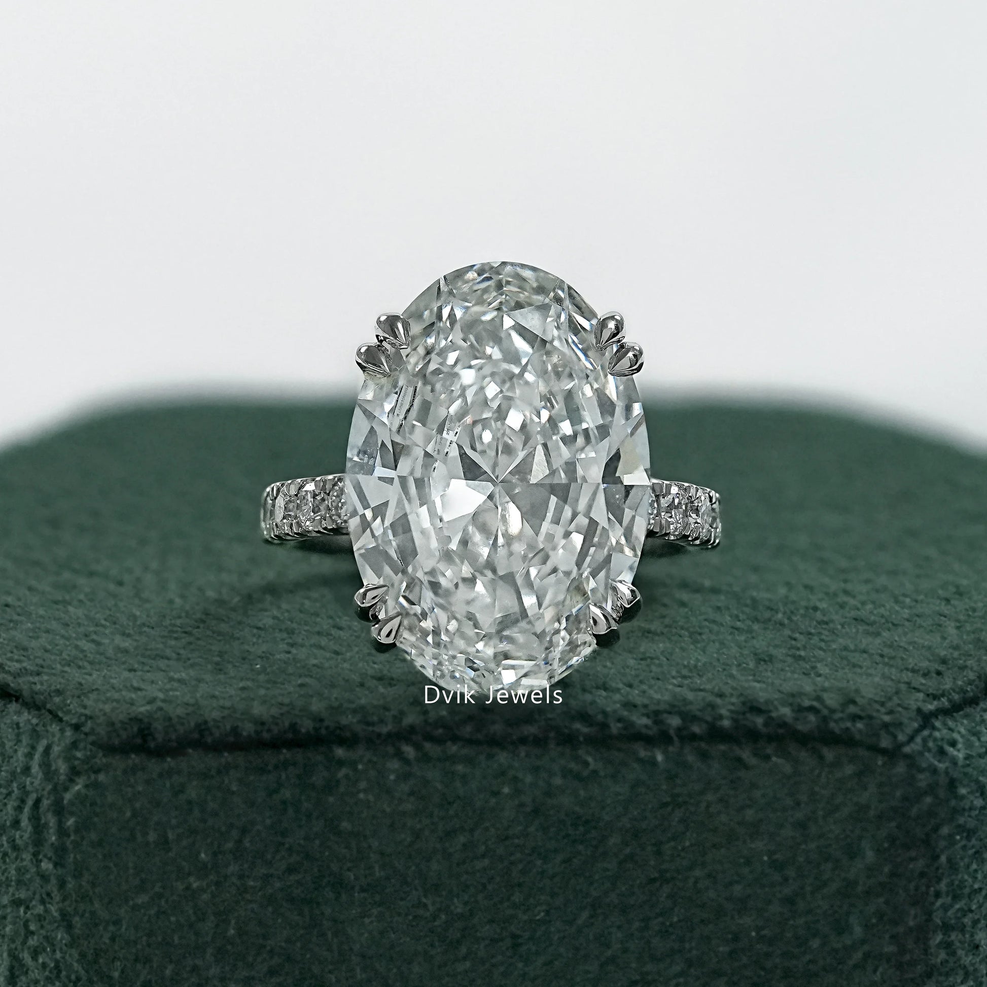 Double prong oval engagement ring held to show the secure corner setting