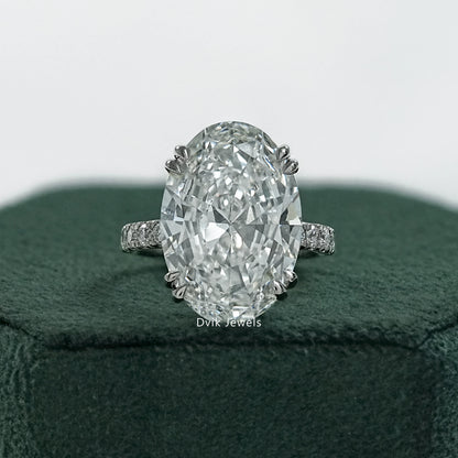 Double prong oval engagement ring held to show the secure corner setting