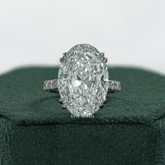 Double prong oval engagement ring held to show the secure corner setting