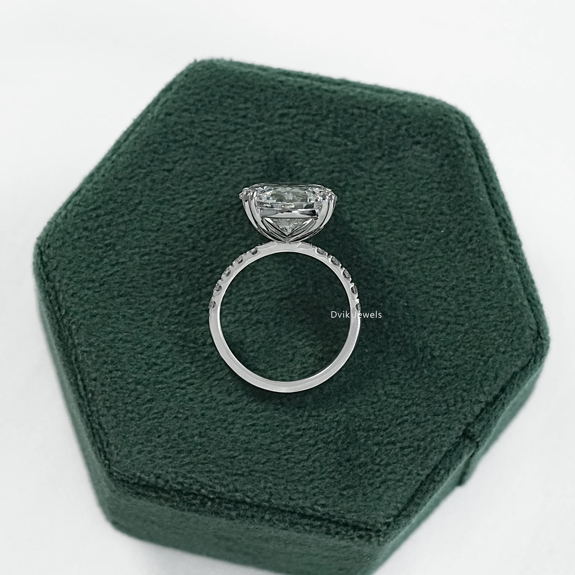 Oval engagement ring with hidden halo displayed on a clean white surface