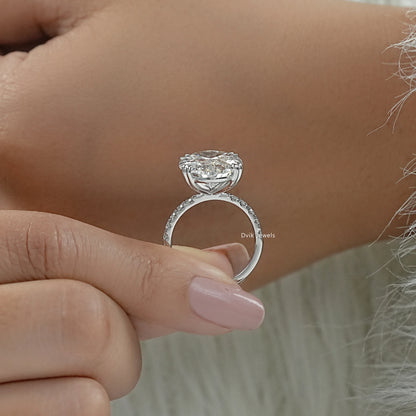 Oval engagement rings with hidden halo held to highlight the under-gallery