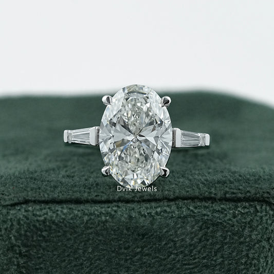 Dvik Jewels Oval Engagement Rings with Side Stones front view placed on dark green velvet.