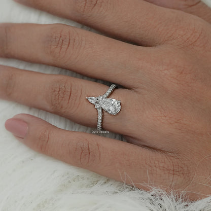 Close-up view of accent engagement ring featuring round center diamond with two pear cut diamond accents