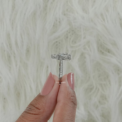 Pear diamond engagement ring with accent setting worn by model hand