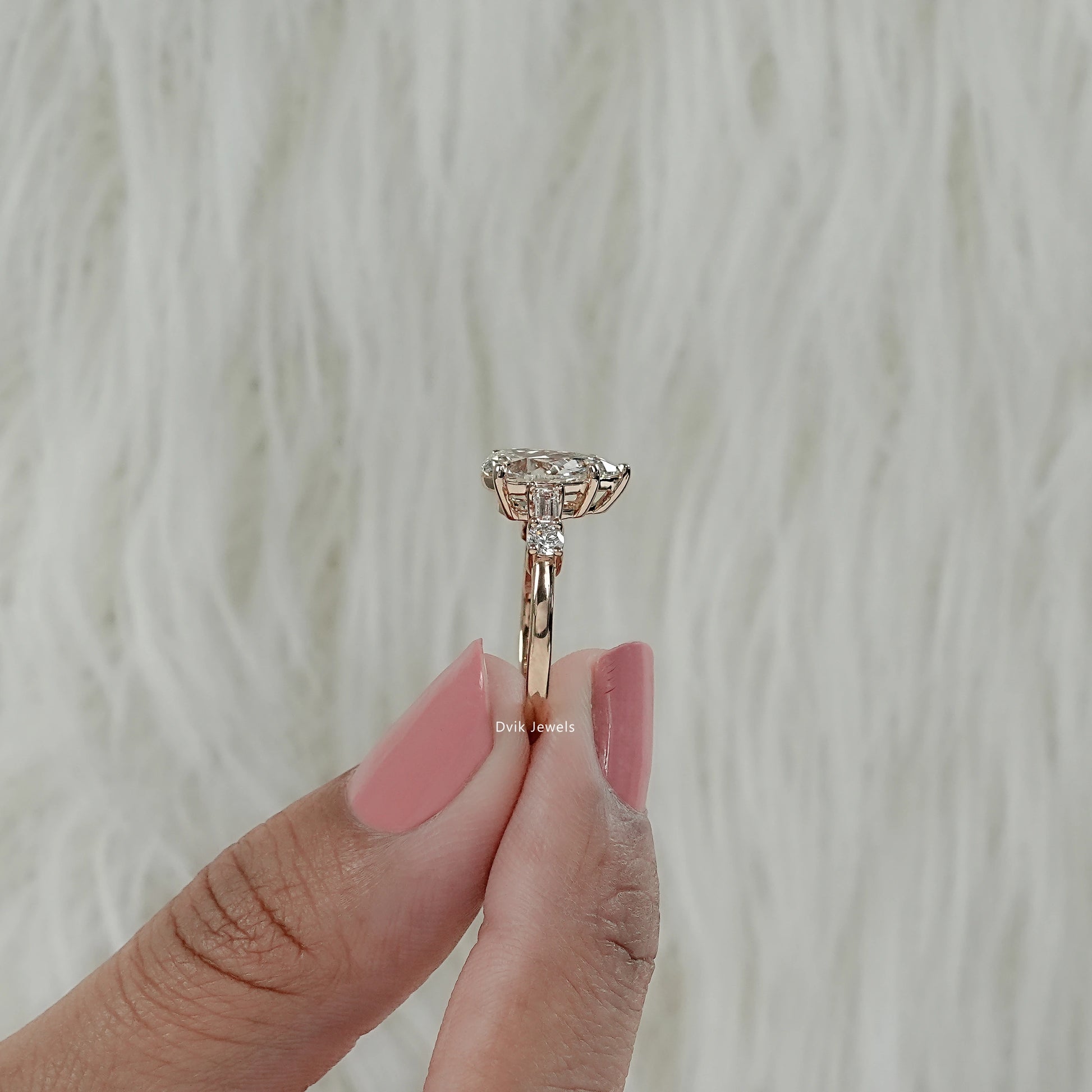 Side view of 5 stone baguette and pear cut engagement ring showing secure prong setting