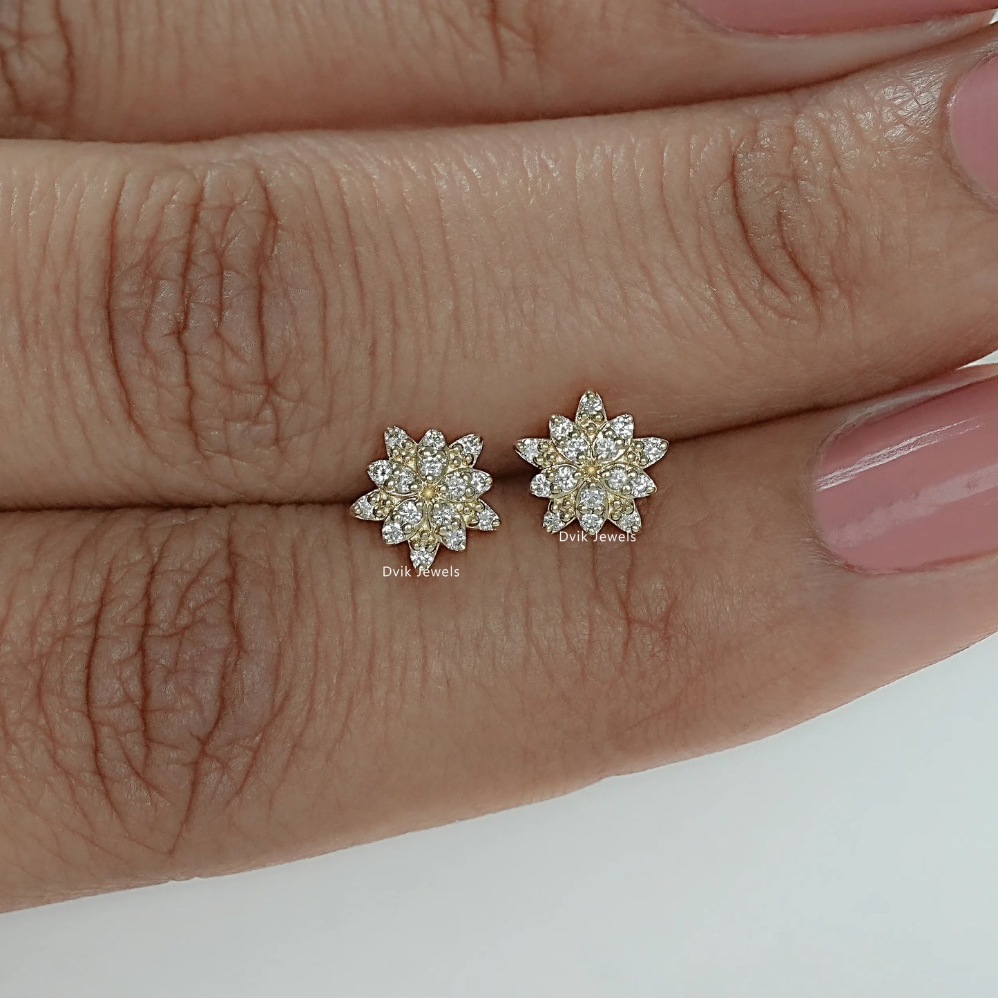 Flower shaped lab diamond earring with round cut diamond hold between fingers