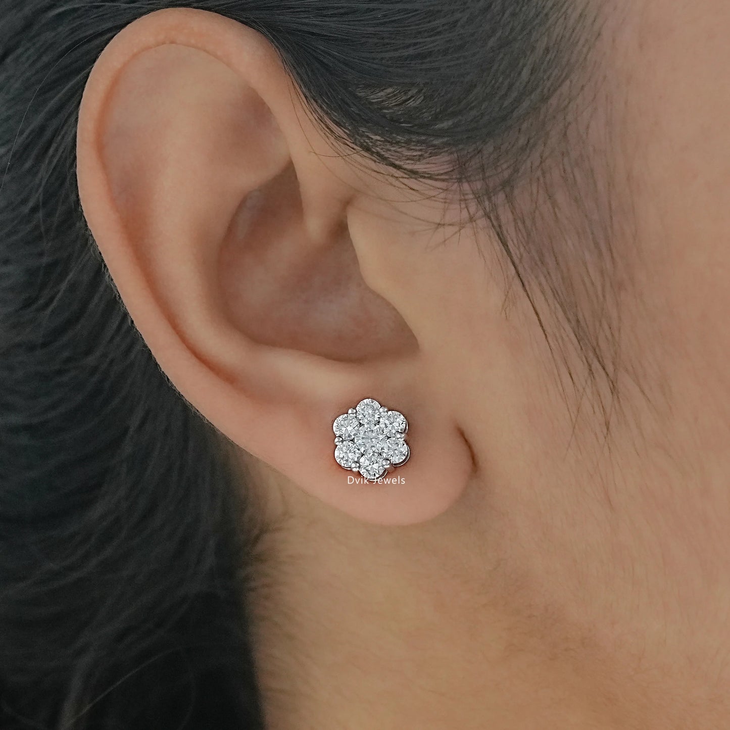 Floral cluster round diamond earrings with prong setting worn by women