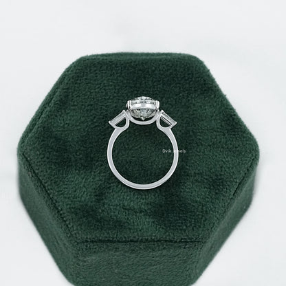 Aerial view of a 3 stone oval engagement ring nestled inside a hexagonal green jewelry case.