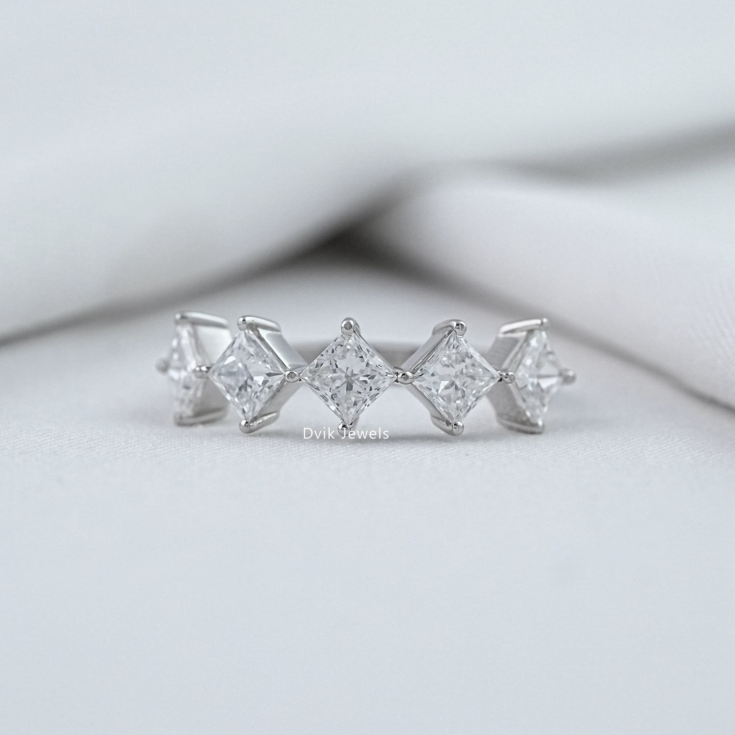 Dvik Jewels princess cut wedding rings white gold front view on soft white fabric.