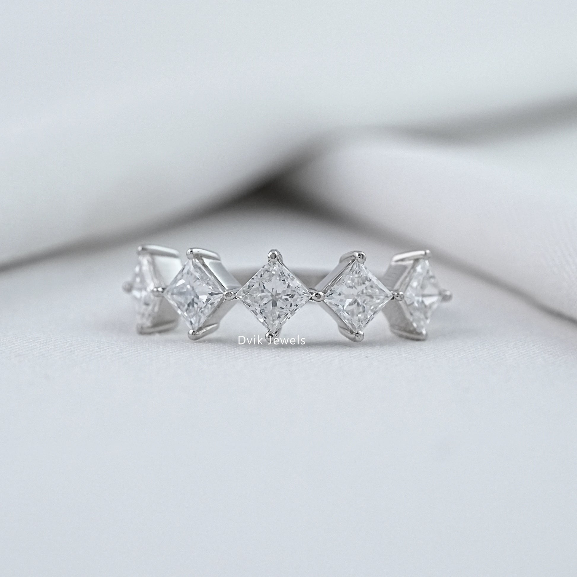 Dvik Jewels princess cut wedding rings white gold front view on soft white fabric.