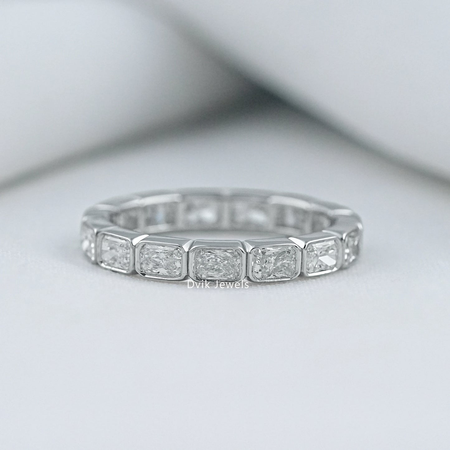 Radiant cut bezel set wedding band in 14k gold with a secure setting