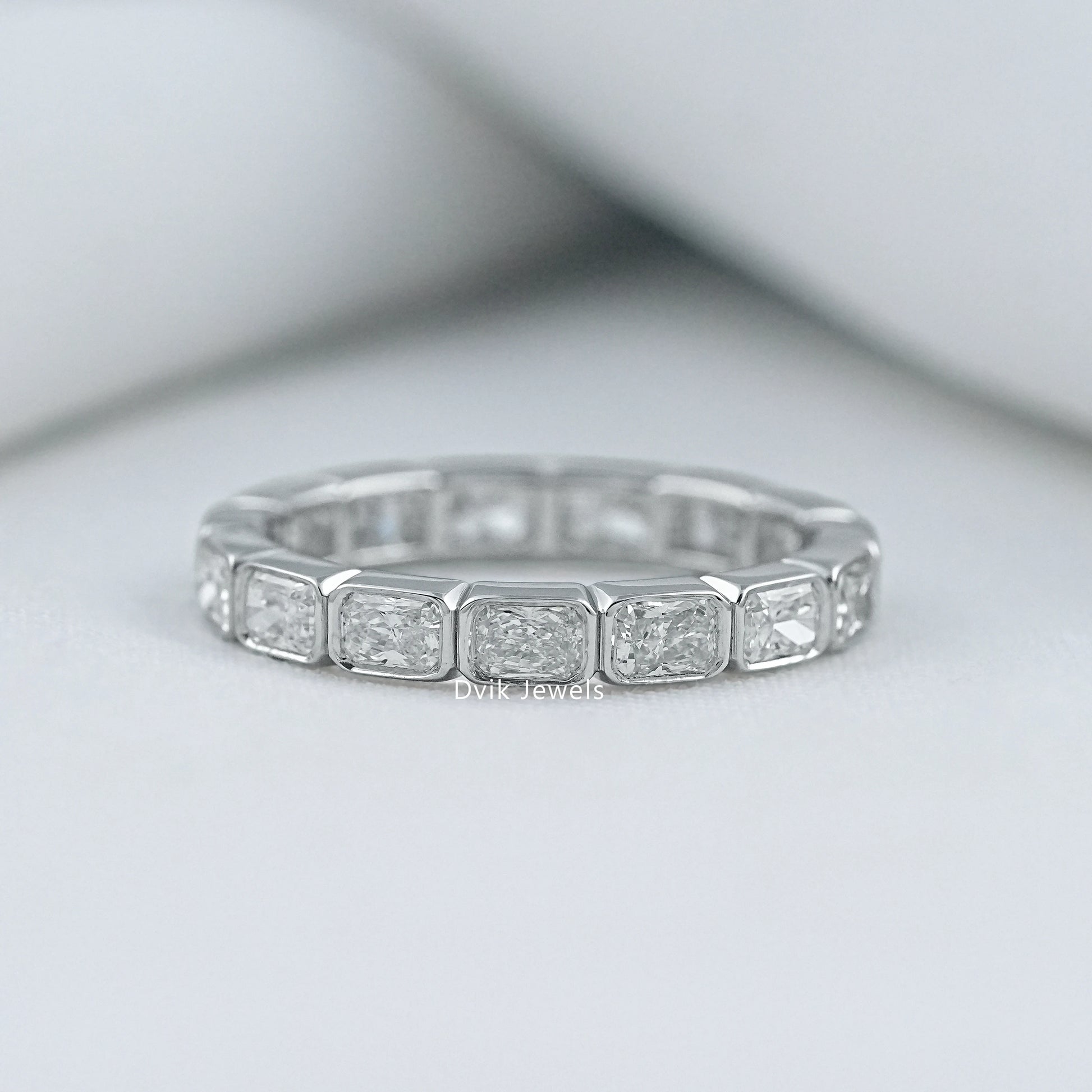 Radiant cut bezel set wedding band in 14k gold with a secure setting