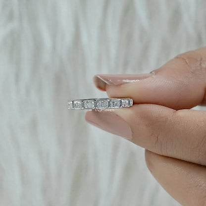 Bezel diamond eternity band held to show the modern polished metal