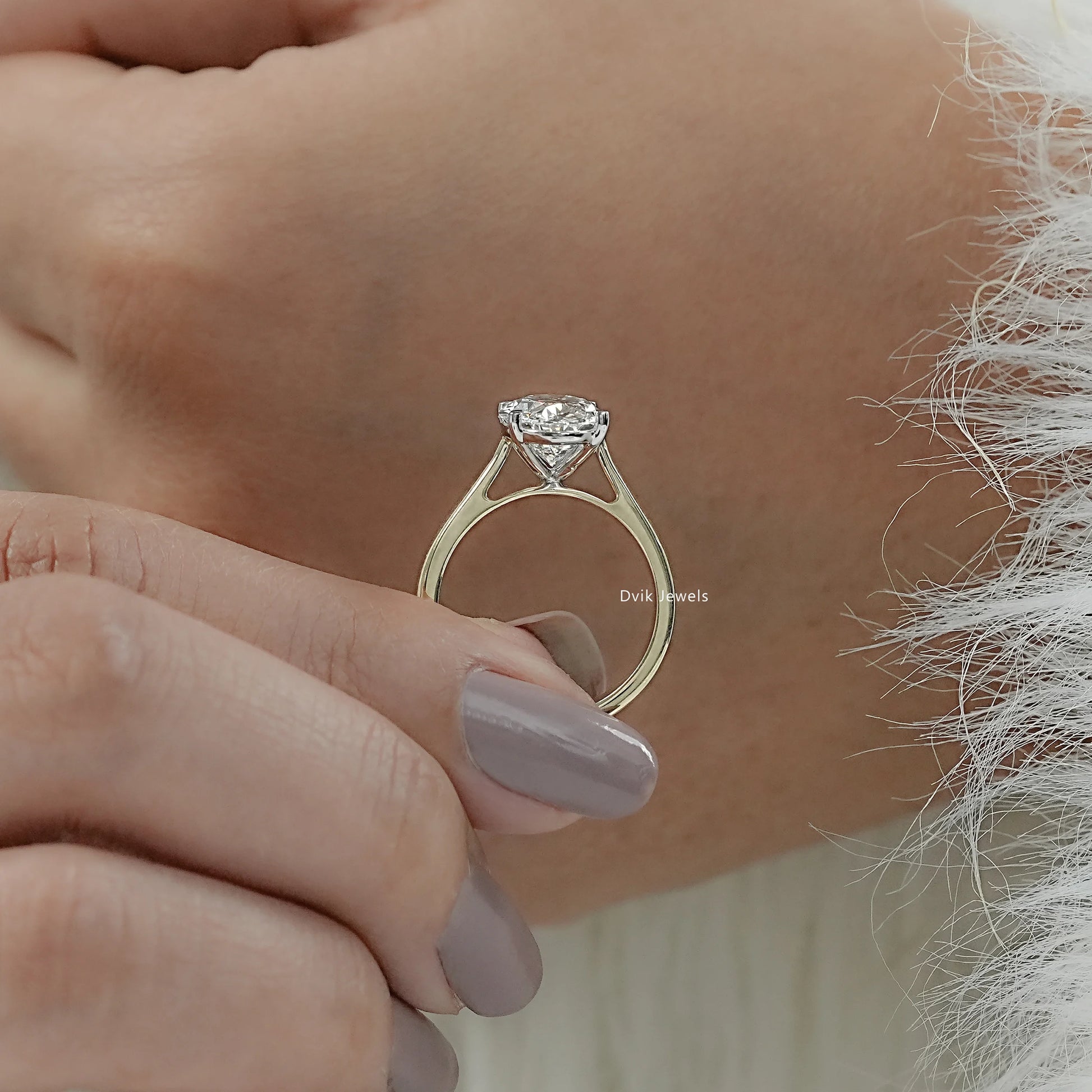 Hand hold view of a big oval engagement ring, highlighting the large surface area and facets.