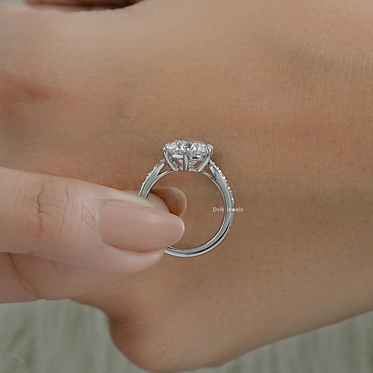 Round diamond engagement ring white gold with detailed side profile view.
