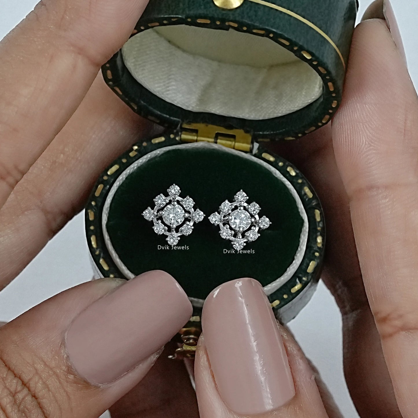 Dvik Jewels cluster diamond earrings front view inside a dark green velvet jewelry case.