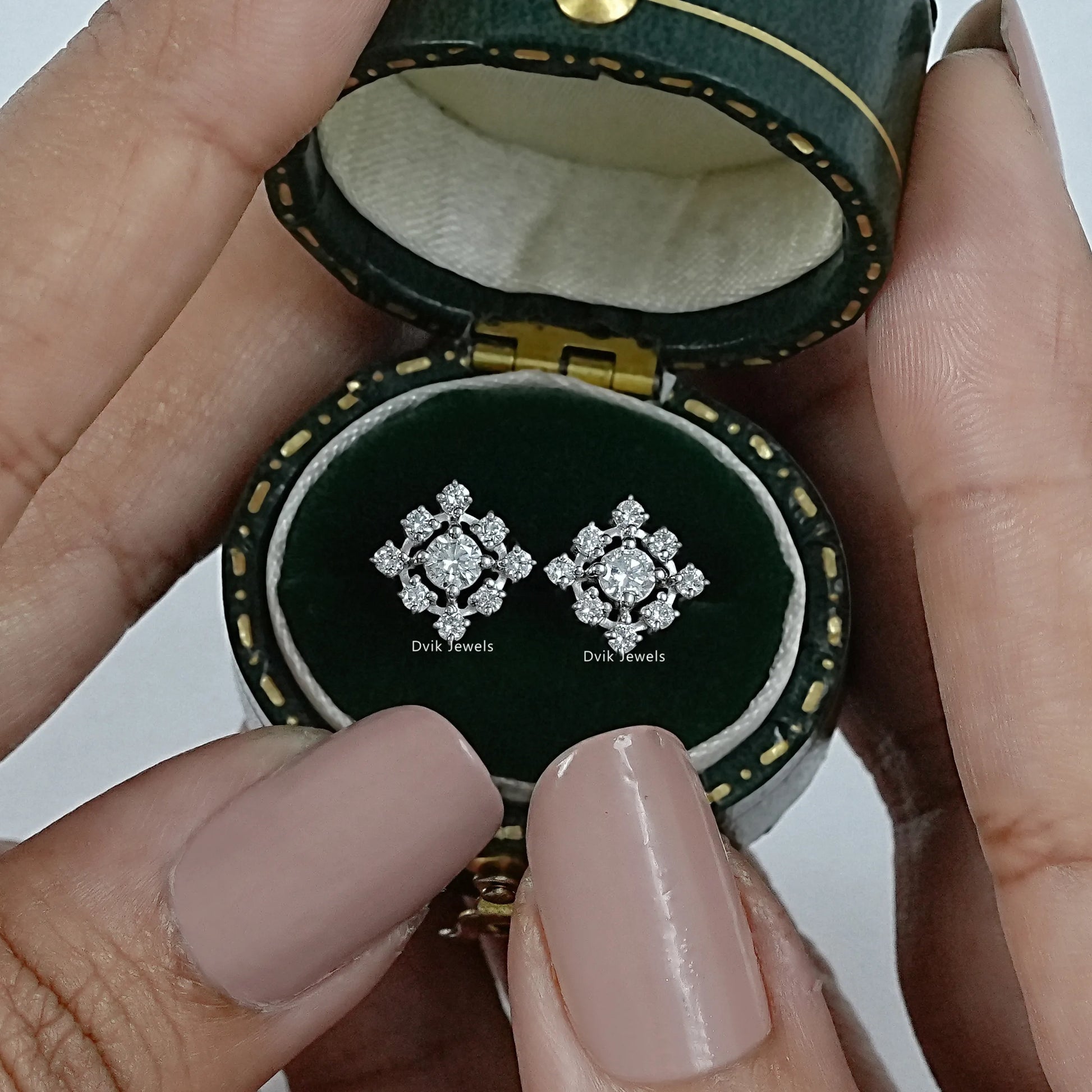 Dvik Jewels cluster diamond earrings front view inside a dark green velvet jewelry case.