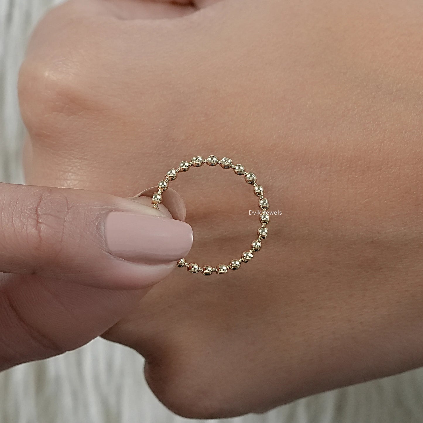 Bubble wedding band yellow gold eternity style held in hand