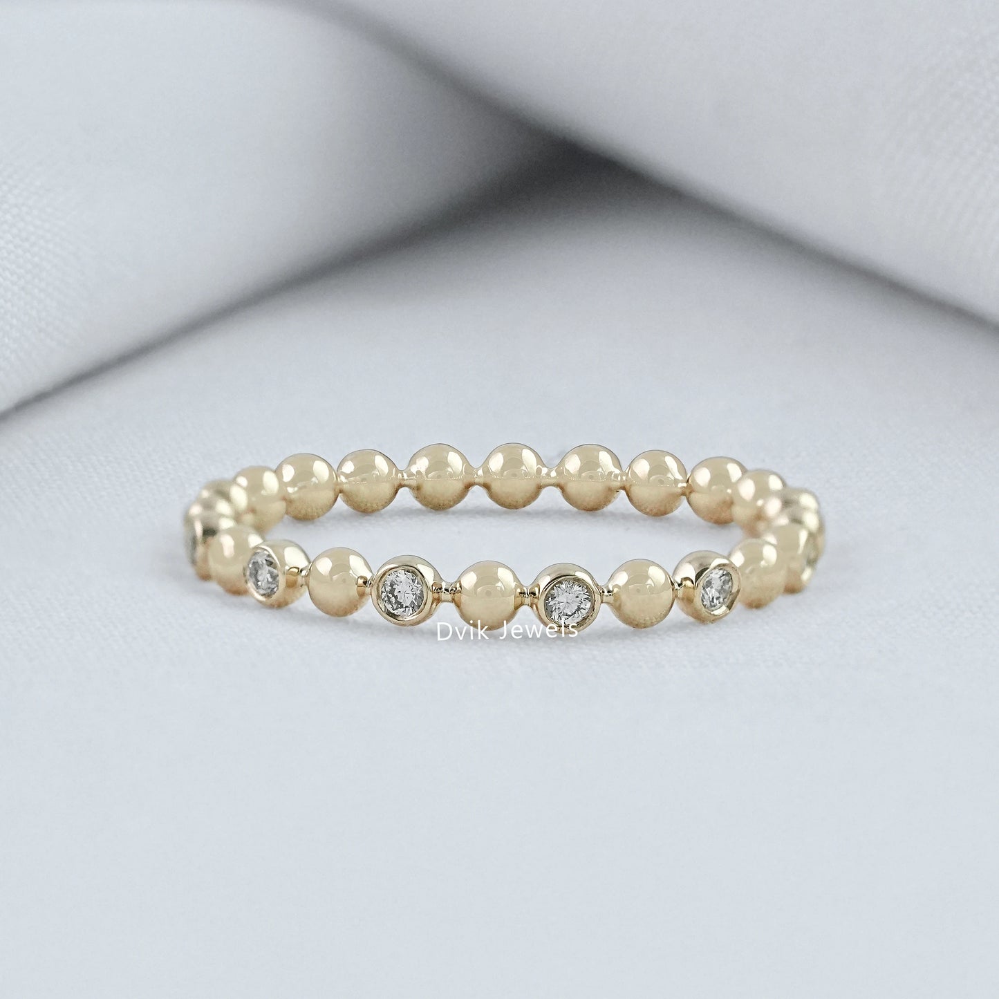 Round cut diamond wedding band yellow gold bezel bubble setting