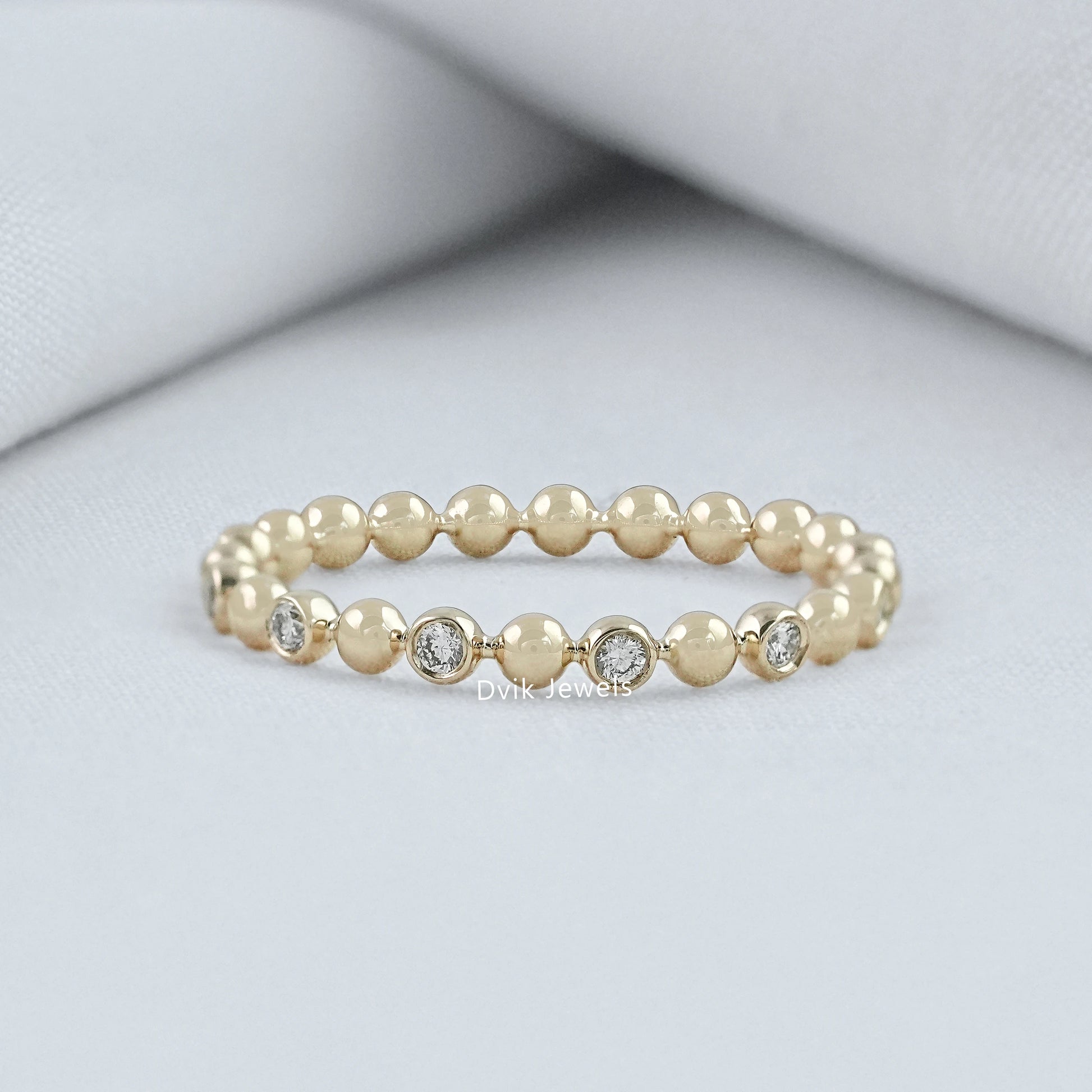 Round cut diamond wedding band yellow gold bezel bubble setting