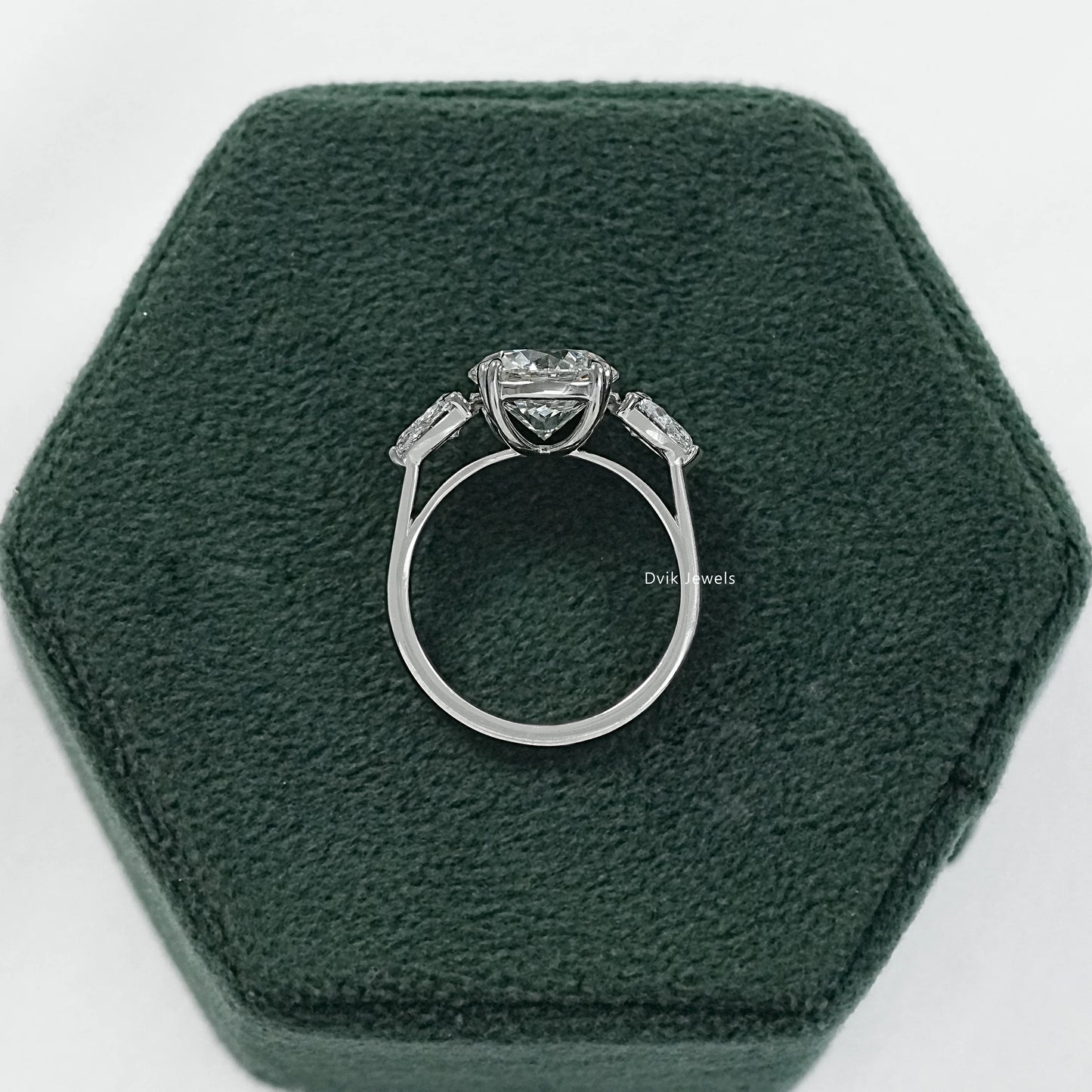 Round engagement ring with pear side stones three stone ring side view