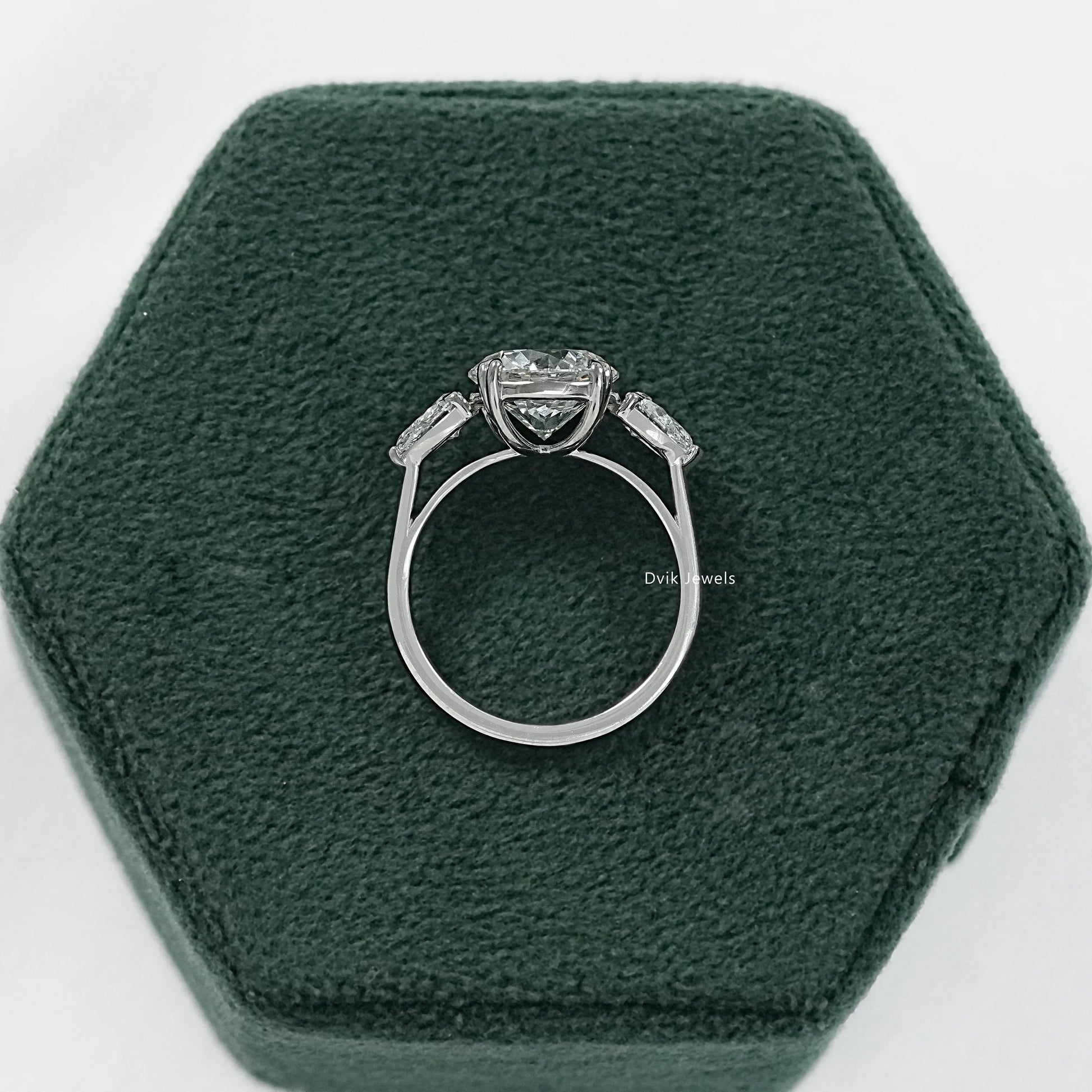 Round engagement ring with pear side stones three stone ring side view