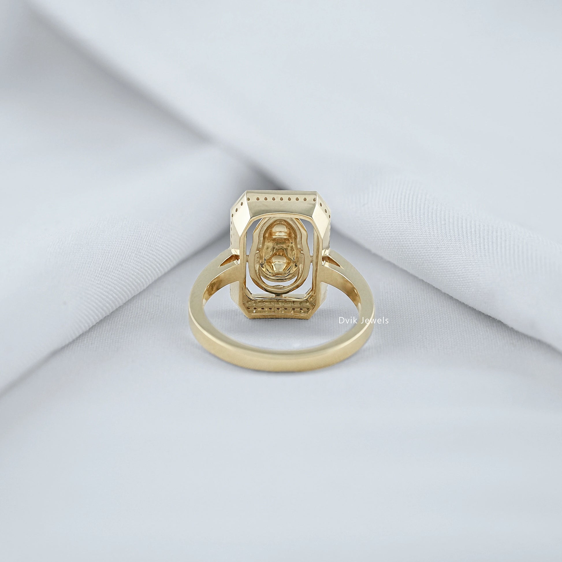 Back view of halo diamond engagement ring showing basket setting and yellow gold band