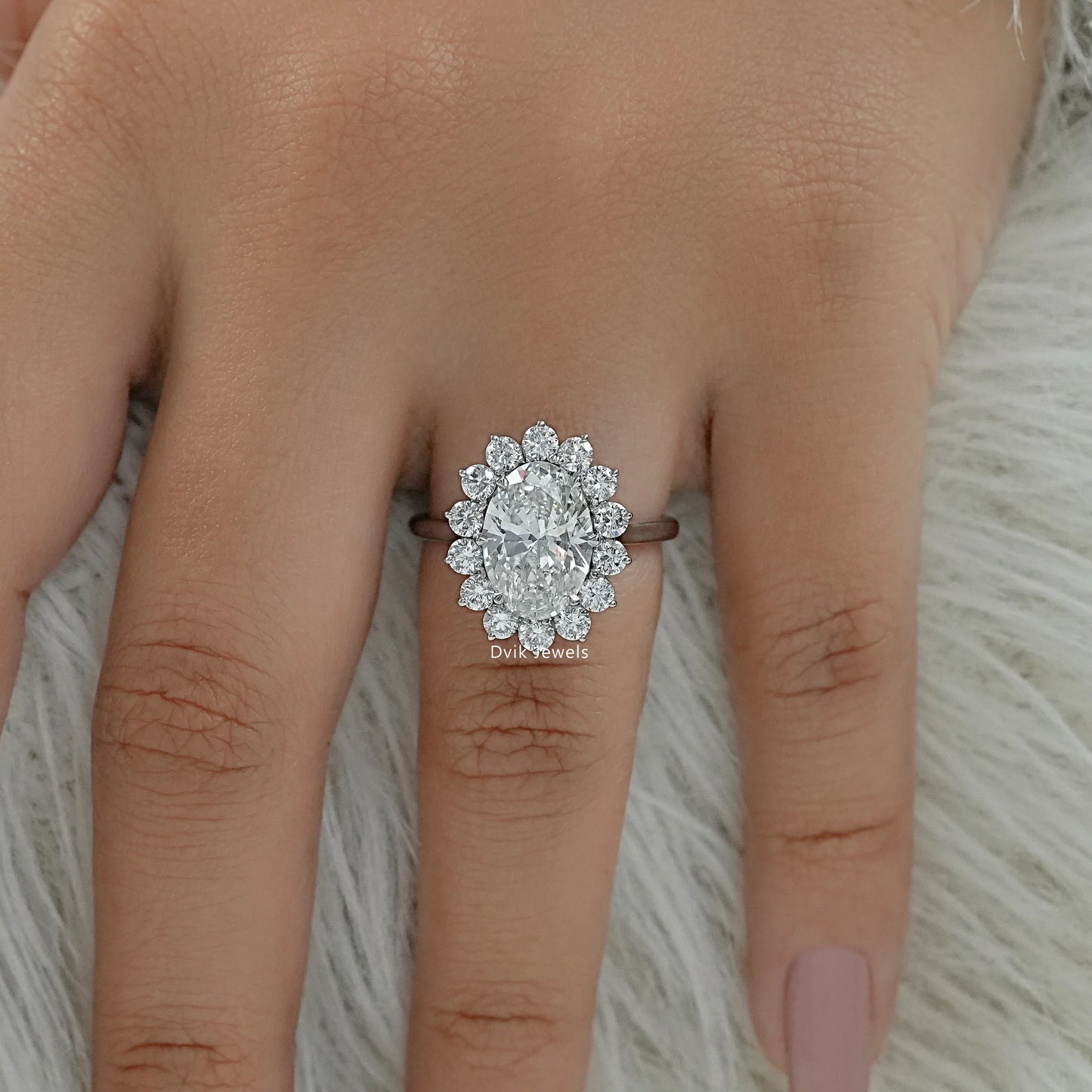 Oval diamond solitaire engagement ring on finger top view