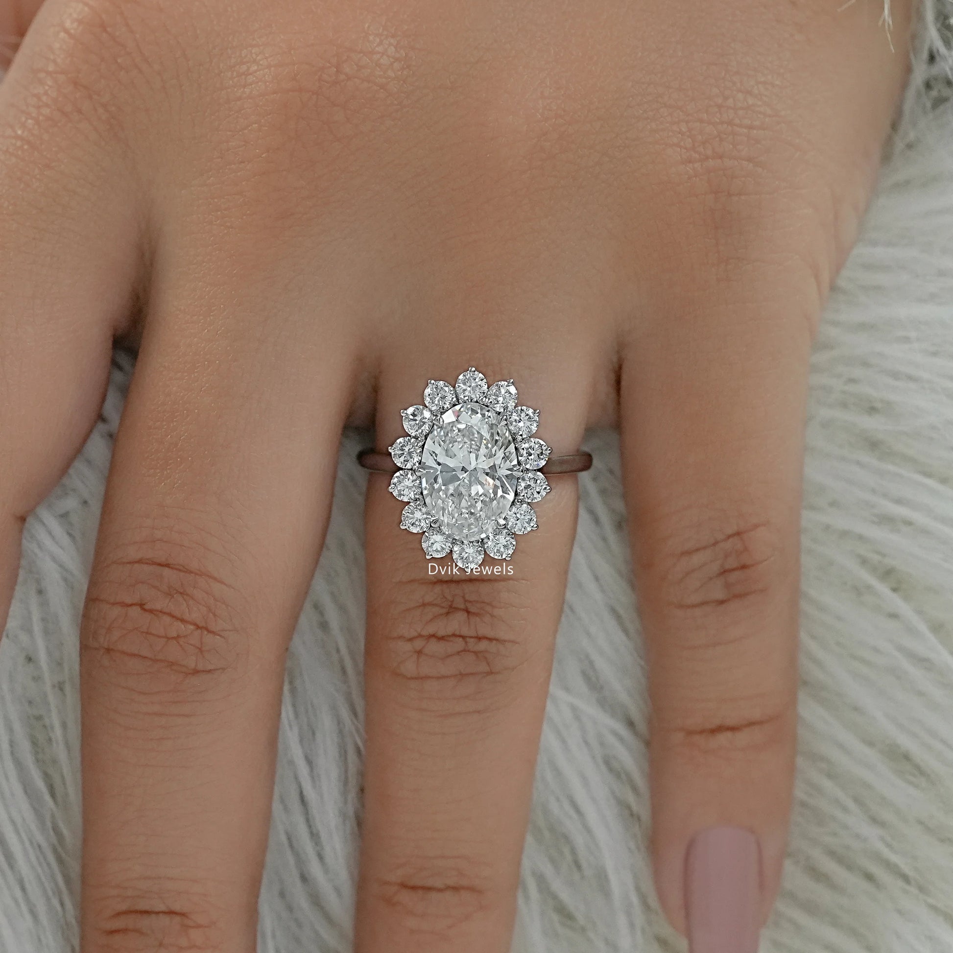Oval diamond solitaire engagement ring on finger top view