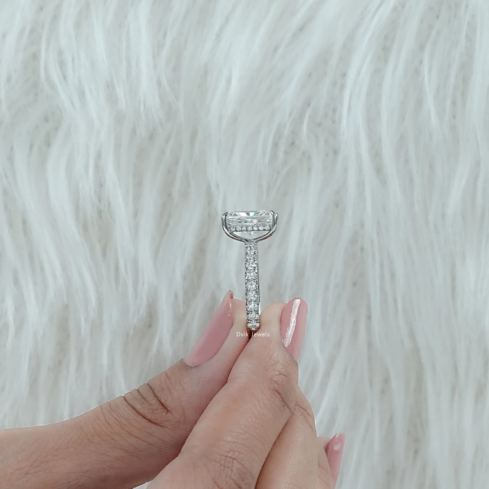 Radiant Cut Lab created Diamond Engagement Ring with Round Cut pave band shown from side angle held by woman