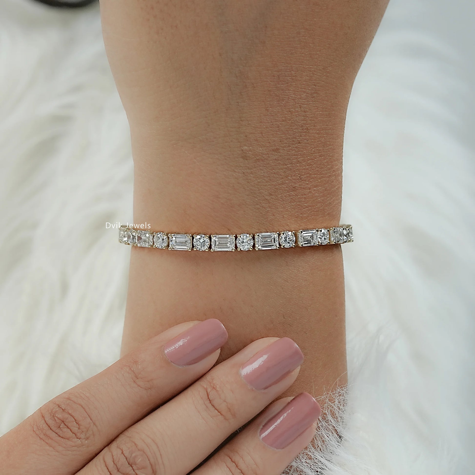 Lab diamond tennis bracelet featuring emerald and round stones on a wrist