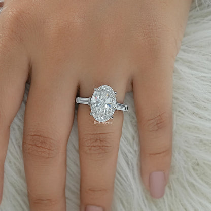 Oval engagement ring with tapered baguettes on finger top view