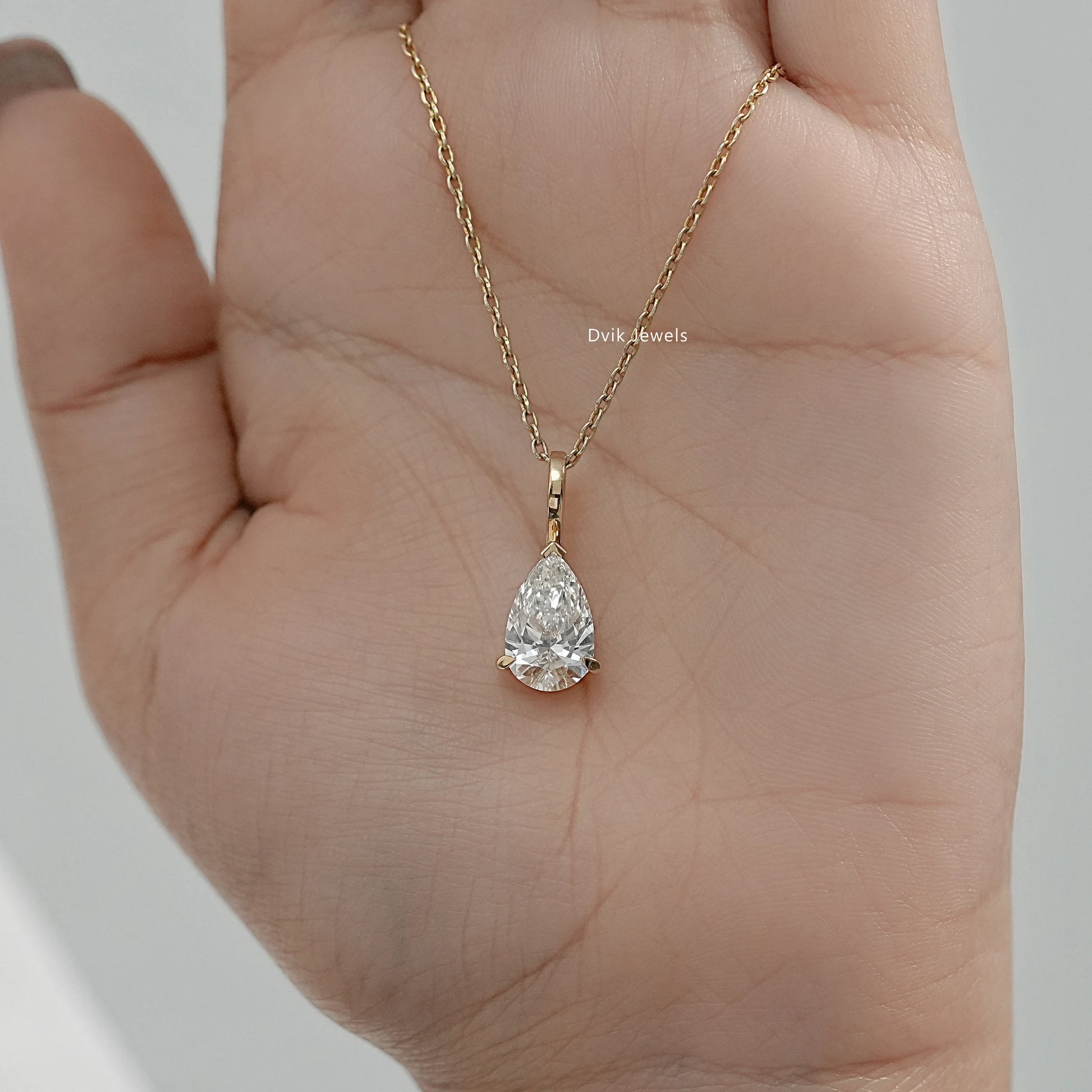 Handheld view of solitaire pear diamond necklace with secure prong setting