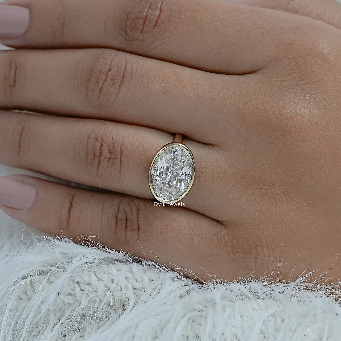 Lab grown diamond oval engagement ring yellow gold bezel on hand