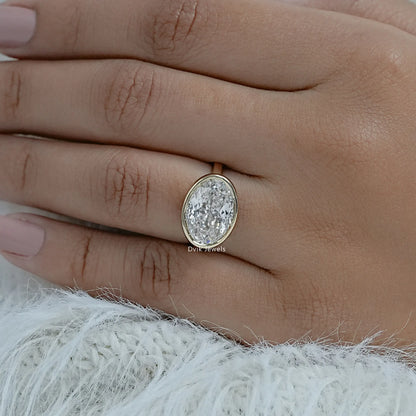 Lab grown diamond oval engagement ring yellow gold bezel on hand