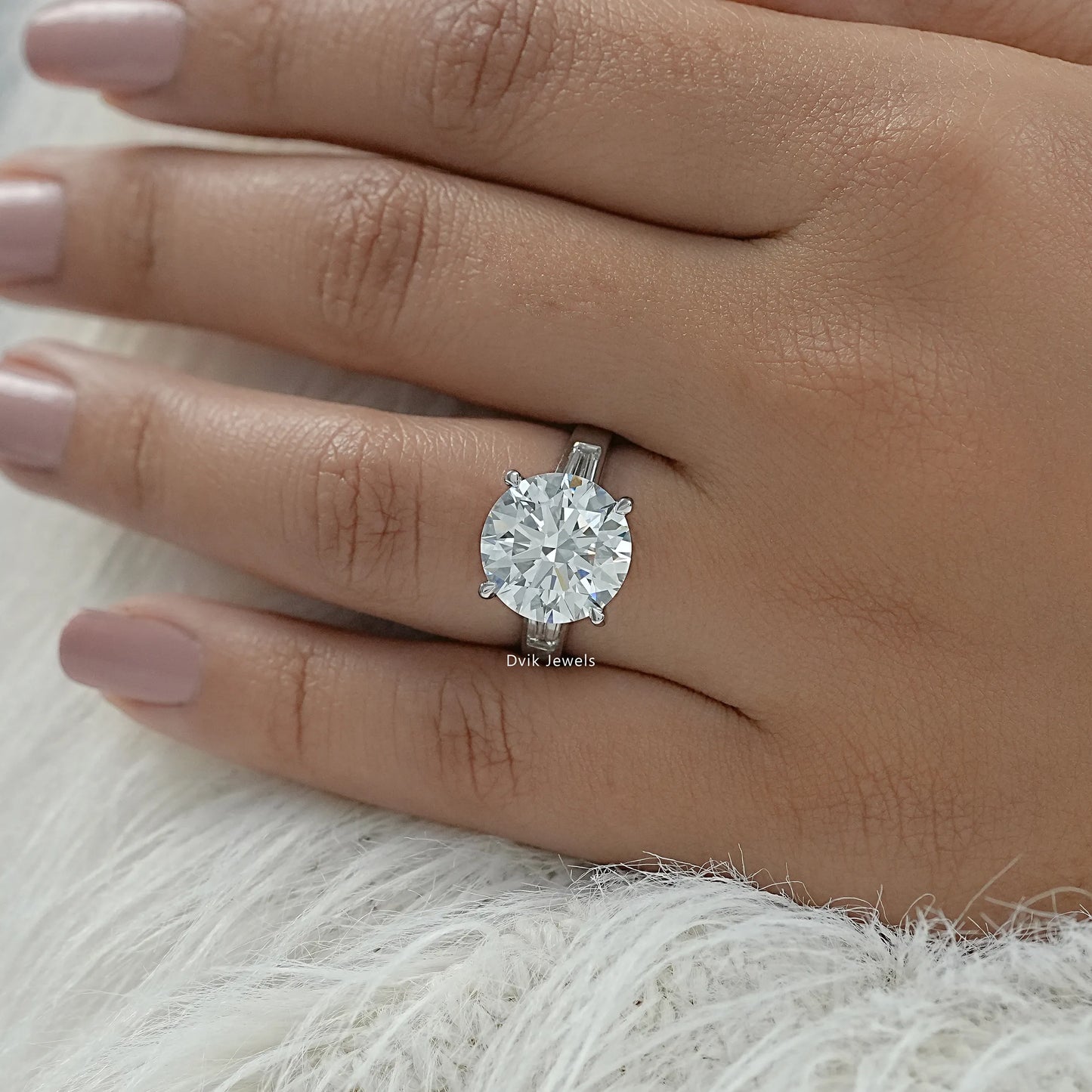 Round diamond with baguettes engagement rings on finger top view
