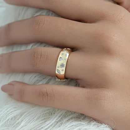 Gypsy set engagement rings held between fingers to show the smooth setting