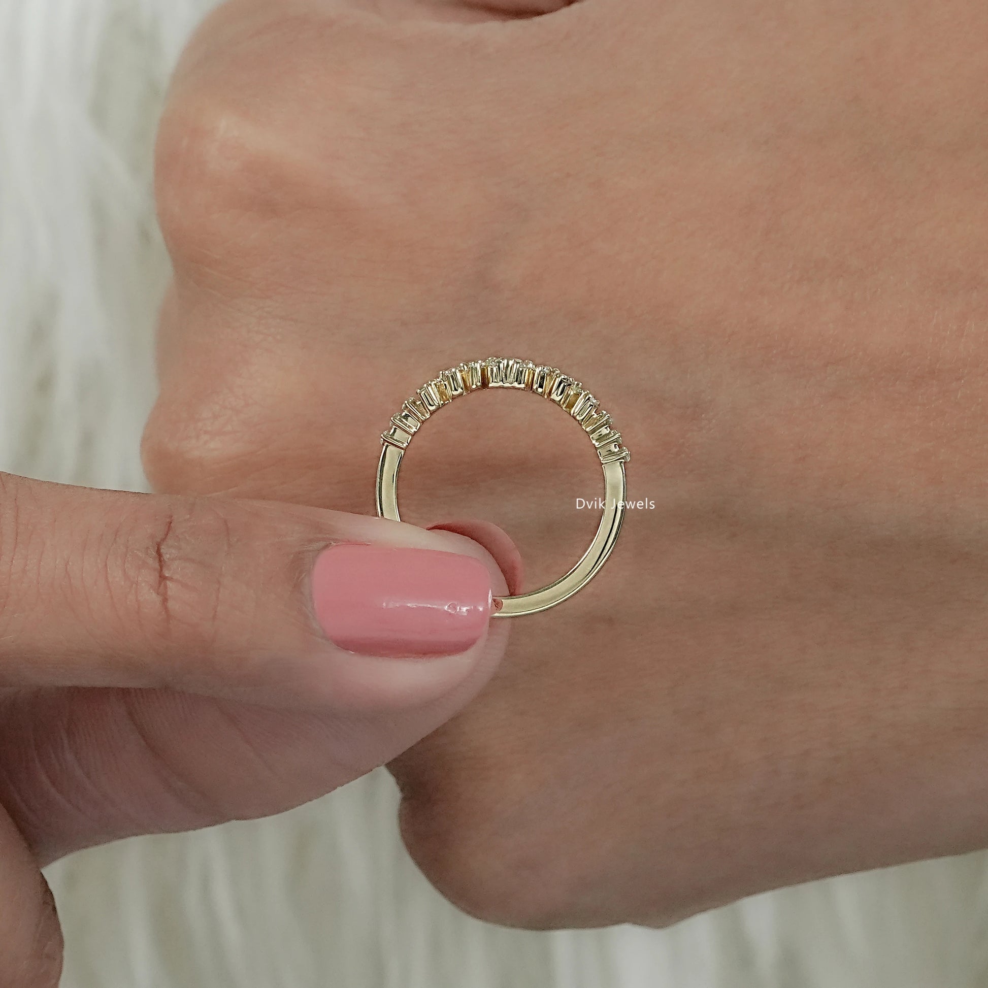 Round diamond ring with accent setting held by women middle view