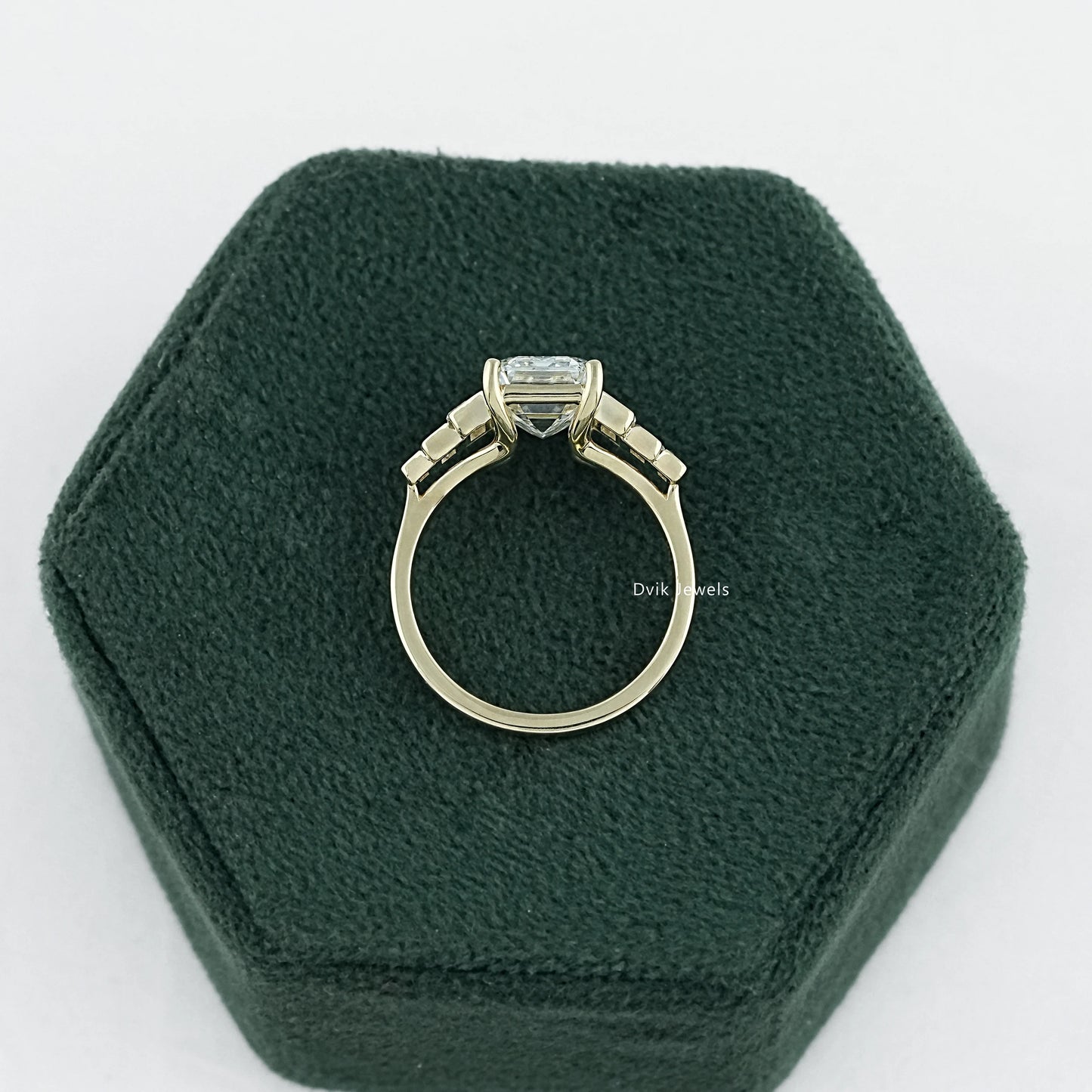 7 stone emerald cut diamond ring held to show the high quality metal band.