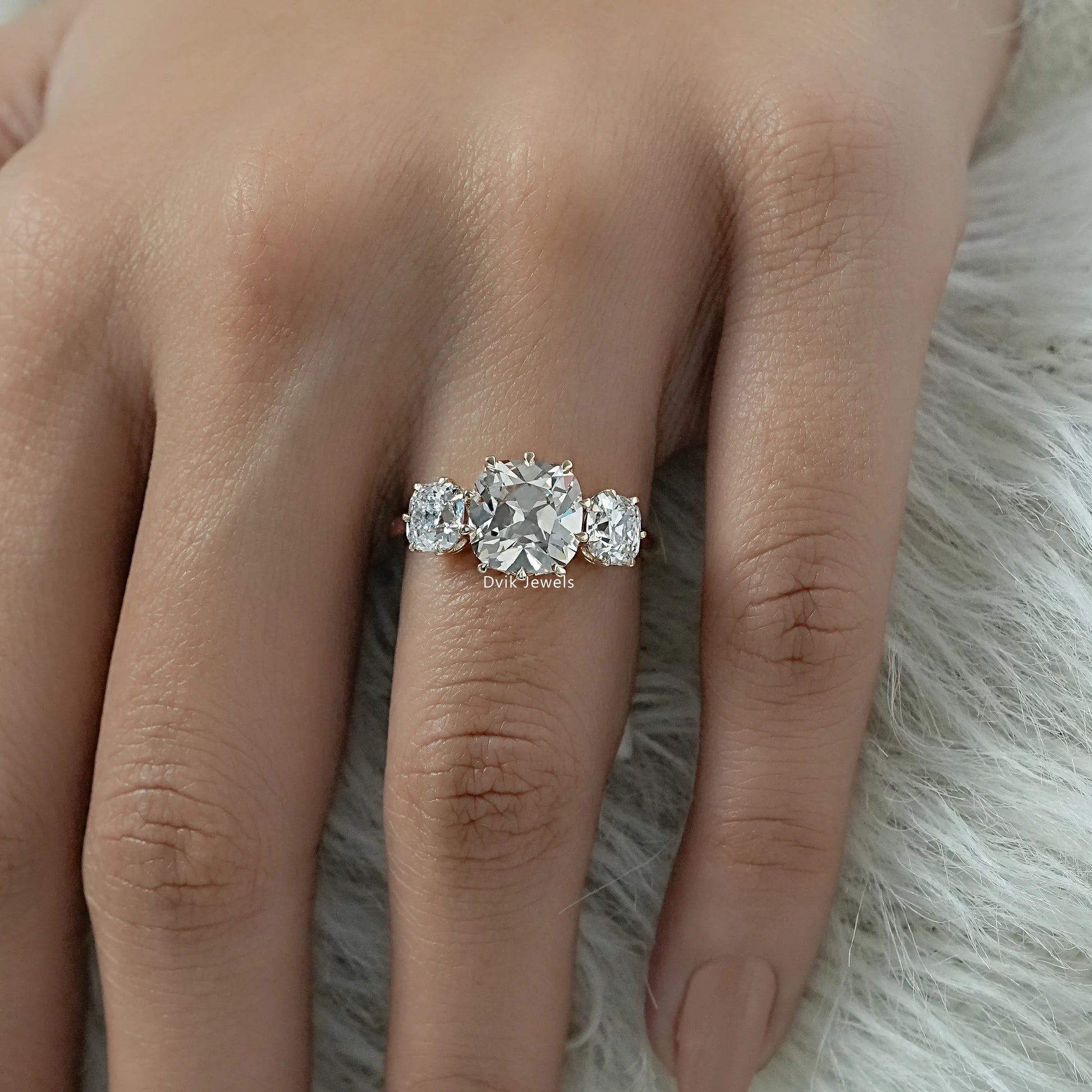 Cushion Cut Three Stone Engagement Ring with a polished metal finish