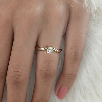 Pear cut curved wavy ring with bezel setting worn by women