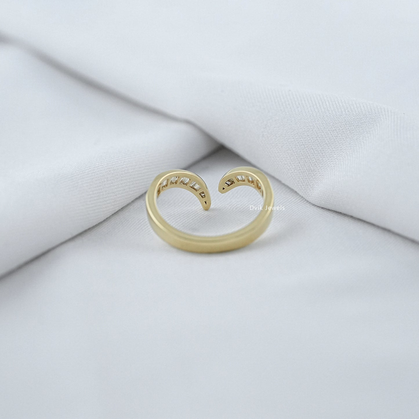 Gold open ring on a white fabric background