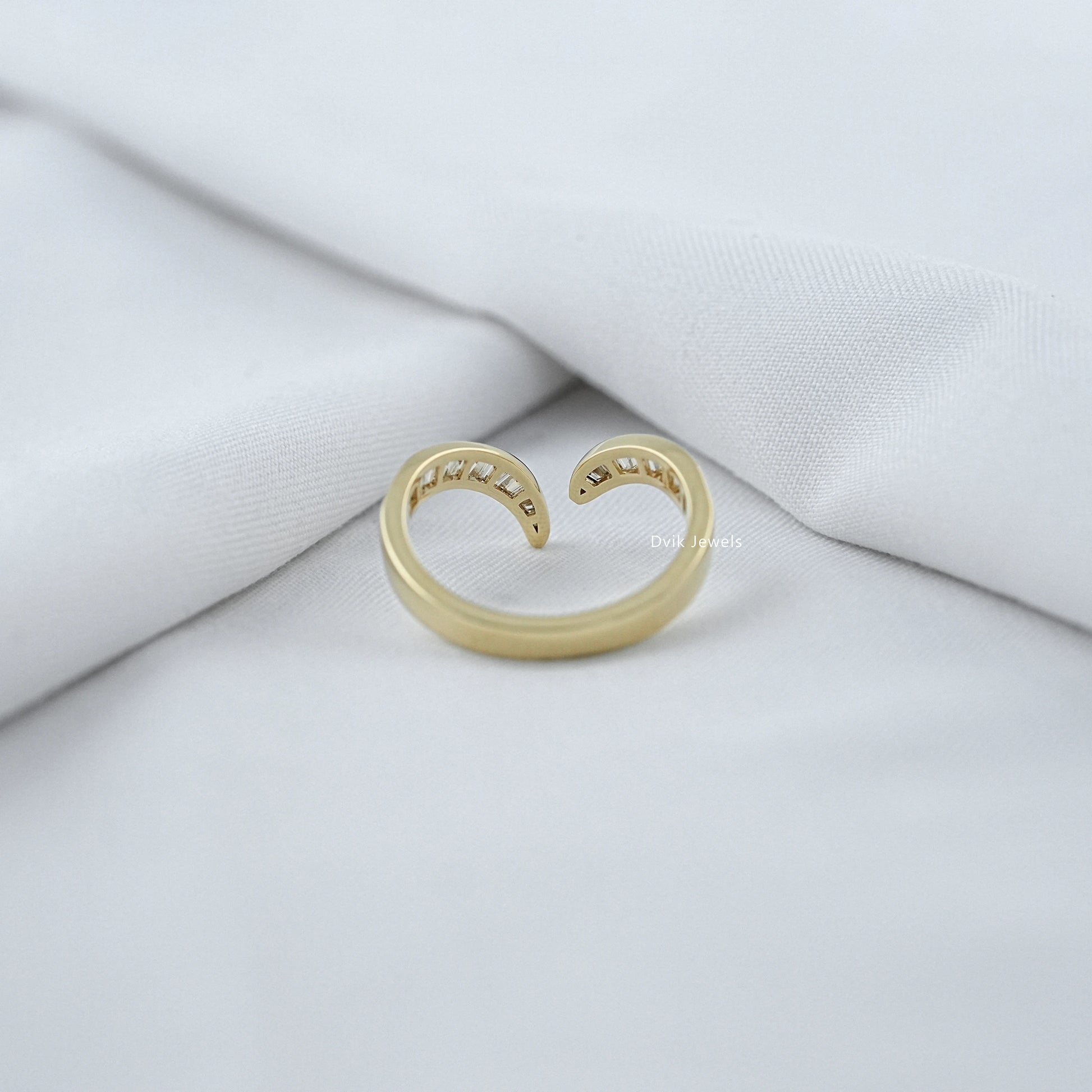 Gold open ring on a white fabric background