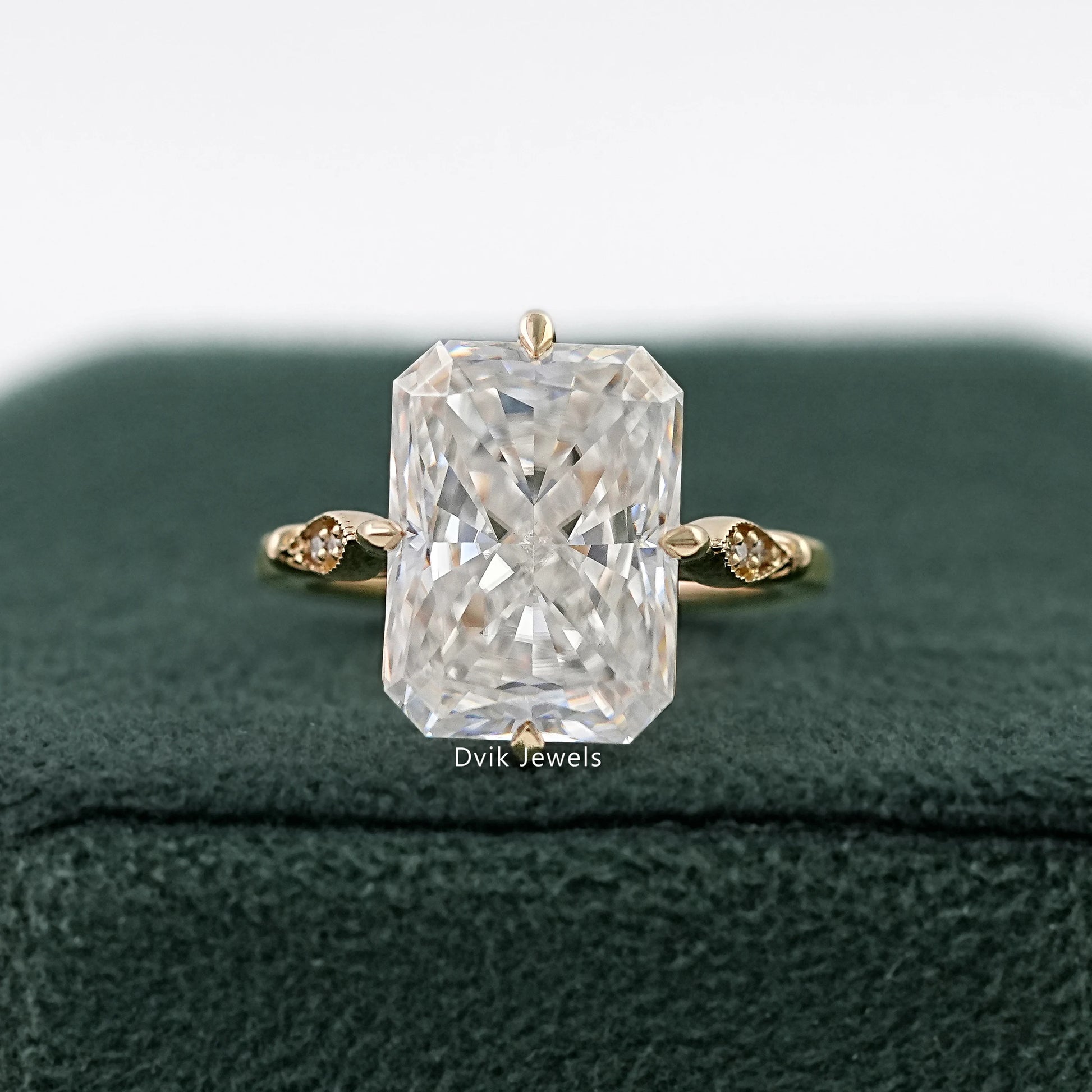 Radiant Cut Solitaire Ring in yellow gold on a green velvet box.